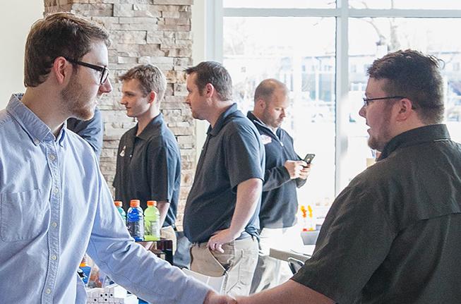 A student shaking someone's hand at a job fair